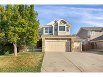 Two-story house with beige siding, stone accents, and a two-car garage at 21787 Unbridled Ave, Parker, CO 80138