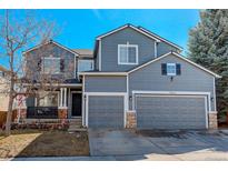 Charming two-story home featuring a two-car garage, stone accents, and a cozy front porch at 9854 Merimbula St, Highlands Ranch, CO 80130