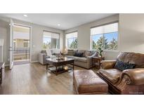 Inviting living room with stylish furniture, wood floors, and bright natural light from large windows at 4265 E Iliff Ave # 1, Denver, CO 80222