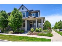 Charming two-story home with a covered front porch and beautifully landscaped front yard at 5799 Boston St, Denver, CO 80238