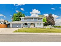 Charming two-story home features a landscaped front yard and a cozy front porch at 10925 W Montana Pl, Lakewood, CO 80232