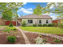 Charming single-story home boasts a landscaped front yard with a stone pathway at 2965 Ivy St, Denver, CO 80207