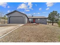 Charming single-Gathering home boasts a well-manicured front yard and attached two-car garage at 6200 Bow Meadows Dr, Elizabeth, CO 80107