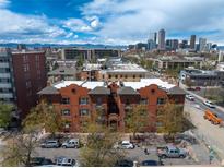 A stunning, vibrant daytime shot of a brick apartment building with a cityscape view including mountains and blue sky at 1475 N Humboldt St # 20, Denver, CO 80218