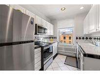 Bright white kitchen featuring stainless steel appliances and black and white tile at 1475 N Humboldt St # 20, Denver, CO 80218