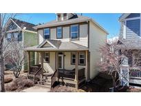 Charming two-story home featuring a welcoming front porch with a gabled roof, wooden railings, and neutral-colored siding at 4523 Crestone Peak St, Brighton, CO 80601
