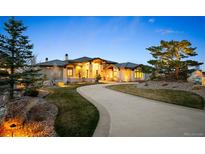 Stunning single Gathering home with a curved driveway and well manicured front yard landscaping at 703 Emberglow Ln, Highlands Ranch, CO 80126