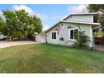 Ranch style home with attached garage and nicely landscaped lawn at 927 Quartz Ct, Longmont, CO 80504