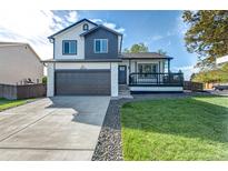 Charming two-story home featuring a modern two-car garage and a welcoming front porch at 12018 Hudson Ct, Thornton, CO 80241
