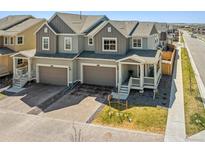 Charming townhome with a welcoming front porch, complemented by modern architectural design and landscaped front yard at 700 Lillibrook Pl, Erie, CO 80026