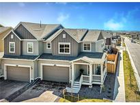 Charming townhome with two-car garage, covered porch, and neutral exterior paint in a well-maintained neighborhood at 700 Lillibrook Pl, Erie, CO 80026