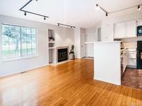 Bright living room with hardwood floors, fireplace, and large window overlooking the yard at 13894 E Lehigh Ave # G, Aurora, CO 80014
