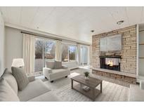 Cozy living room featuring a stone fireplace, sliding glass doors to the yard, and neutral finishes at 1355 Rosemary St, Denver, CO 80220