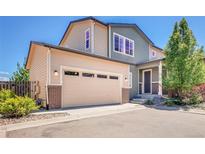 Beautiful two-story home featuring a beige garage door and a blend of beige and green siding at 17186 E Cedar Gulch Dr, Parker, CO 80134
