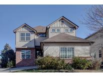 Charming two-story home featuring neutral siding, brick accents, and a well-maintained front yard at 1710 S Poplar St, Denver, CO 80224