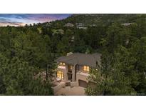 Stunning stucco home surrounded by mature trees, offering privacy and curb appeal at 209 Saratoga Mine Dr, Castle Rock, CO 80108