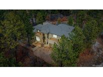 Beautiful home featuring a tile roof, large windows, and a private driveway surrounded by mature trees at 209 Saratoga Mine Dr, Castle Rock, CO 80108