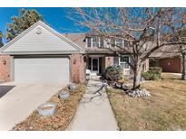 Charming two-story brick home with a manicured lawn and a two-car garage at 6023 E Briarwood Dr, Centennial, CO 80112
