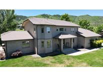 Charming two-story home with a well-maintained lawn and a picturesque mountain backdrop at 10886 Pheasant Run, Littleton, CO 80125