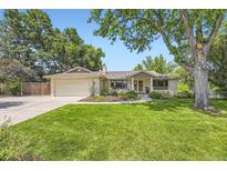 Charming single-story home with a well-manicured lawn and mature trees at 5475 W Ottawa Ave, Littleton, CO 80128