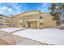 Two-story condo building featuring a well-maintained lawn and snow covered ground at 710 S Clinton St # 6A, Denver, CO 80247