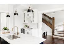 Kitchen features white cabinets, marble counters, and a breakfast bar at 3044 W 29Th Ave, Denver, CO 80211