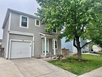 Charming two-story home with attached garage, well-maintained lawn, and mature trees in a serene neighborhood at 1286 Finch Ave, Brighton, CO 80601