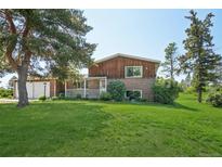 Charming two-story brick home featuring a well-maintained lawn and a classic front porch at 8840 Niwot Rd, Niwot, CO 80503