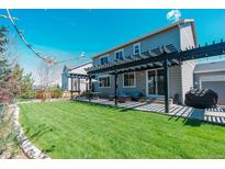 Beautiful backyard featuring a large lawn and a covered patio with outdoor furniture at 7665 Grady Cir, Castle Rock, CO 80108