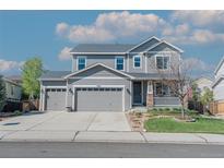 Charming two-story home with a three-car garage, covered porch, and manicured lawn at 7665 Grady Cir, Castle Rock, CO 80108