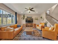 Bright living room features hardwood floors, ceiling fan, and comfortable leather furniture at 7665 Grady Cir, Castle Rock, CO 80108