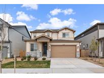 Charming two-story home with a well-manicured lawn, gray stone accents, and a two-car garage at 14268 Hop Clover Trl, Parker, CO 80134