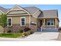 Charming exterior with stone accents, manicured lawn and an inviting front porch at 7426 E 148Th Pl, Thornton, CO 80602
