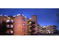 Brick apartment building with multiple levels and balconies at dusk at 800 W Belleview Ave # 407, Englewood, CO 80110