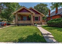 Brick home with a charming front porch and well-manicured lawn at 3560 N Columbine St, Denver, CO 80205