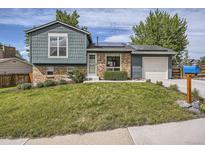 Charming two-story home featuring a well-manicured lawn, brick accents, and solar panels on the roof at 9430 Carr St, Westminster, CO 80021