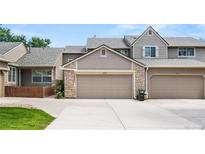 Exterior view of a two-story townhome with a two-car garage and beautiful stone accents at 6664 S Webster St, Littleton, CO 80123