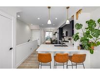 Modern kitchen featuring a large island with seating and stylish pendant lighting at 4925 W 10Th Ave # 111, Denver, CO 80204