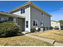 Two-story home with gray siding, brick accents, a well-manicured lawn, and a walkway leading to the front door at 3225 S Garrison St # 19, Lakewood, CO 80227