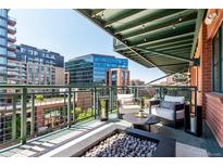 Relaxing balcony featuring comfortable seating and a modern fire pit with views of downtown at 1735 19Th St # 6D, Denver, CO 80202