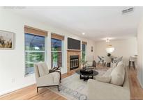 Inviting living room featuring a cozy fireplace, large windows and gorgeous wood flooring throughout at 1030 Jersey St # 1, Denver, CO 80220