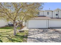 Charming townhome with a two-car garage, beautiful tree, and well-maintained lawn at 5559 S Quemoy Cir, Aurora, CO 80015