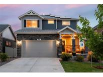 Charming two-story home featuring a stone facade, covered porch, and solar panels, perfect for modern living at 56 Magnolia Ct, Erie, CO 80516
