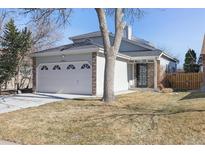 Charming home featuring a two-car garage, well-maintained lawn, and a cozy entryway at 5664 S Zang St, Littleton, CO 80127