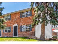 Two-story brick townhouse with a well-maintained lawn and mature trees at 13977 E Bails Pl, Aurora, CO 80012