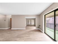 Bright living room with wood-look floors and sliding glass doors to a private balcony at 14091 E Marina Dr # 308, Aurora, CO 80014
