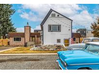 Unique two-story home exterior with a combination of vintage cars in the driveway at 2831 & 2833 Reed St, Wheat Ridge, CO 80033