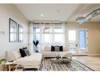 Bright living room featuring neutral decor, modern furnishings, and an eye-catching patterned rug at 3198 Blake St # 402, Denver, CO 80205