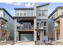 Two-story home with gray siding, stone accents, and a two-car garage at 15644 W Floyd Dr, Morrison, CO 80465