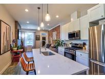 Bright, open kitchen featuring a quartz island, modern appliances, and pendant lighting at 1739 E Martin Luther King Jr Blvd, Denver, CO 80205
